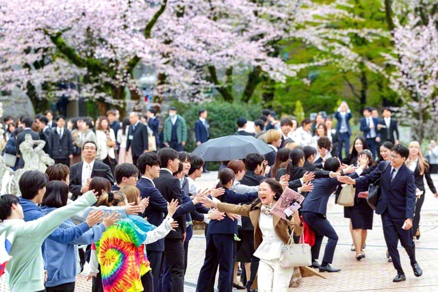 入学式の会場となった創大池田記念講堂の前で、在学生たちが新入生を温かく歓迎