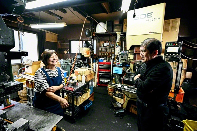「ケンカしても、仕事してるうちに仲直りしちゃうの」と妻・れい子さん㊧は笑う。夫婦で肩を並べ、プレス機を操る