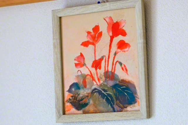 畠山さんが作製した、シクラメンのちぎり絵。優しき紅がともる