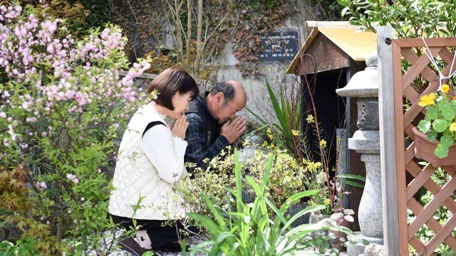 園田久美代さん㊧が夫・幸治さんと共に、花で彩られた自宅の庭の一角で