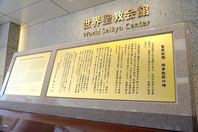 世界聖教会館の入り口にある「聖教新聞　師弟凱歌の碑」には「一人一人に励ましの手紙を綴る思いで、ペンの闘争に挑み抜いてきた」との池田先生の真情が刻まれている