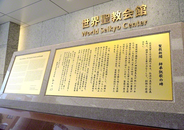 世界聖教会館の入り口にある「聖教新聞　師弟凱歌の碑」には「一人一人に励ましの手紙を綴る思いで、ペンの闘争に挑み抜いてきた」との池田先生の真情が刻まれている