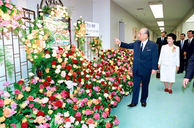 同志から贈られた色とりどりの花々を丹念に見る池田先生。全ての友に幸福と勝利の花々が爛漫と咲くよう願いつつ（2001年4月、巣鴨の東京戸田記念講堂で）