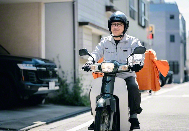 バイクで集配に向かう夫・勝利さん。遠方のお客や来店が難しい高齢者など、集配を求める声は多いという