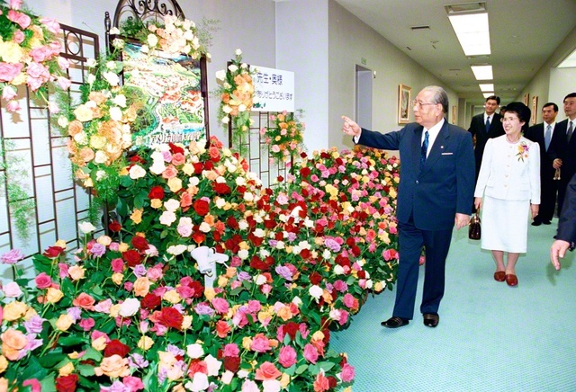 同志から贈られた色とりどりの花々を丹念に見る池田先生。全ての友に幸福と勝利の花々が爛漫と咲くよう願いつつ（2001年4月、巣鴨の東京戸田記念講堂で）