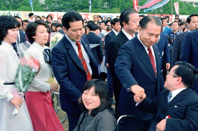 「5・3」を祝賀する集いで、池田先生が自由グループ、自在会、妙音会の友が座る招待席へ。一人一人と握手を交わし、励ましを送った（1981年5月3日、創価大学で）