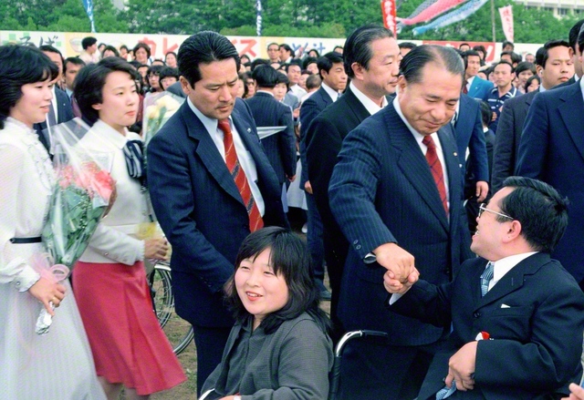 「5・3」を祝賀する集いで、池田先生が自由グループ、自在会、妙音会の友が座る招待席へ。一人一人と握手を交わし、励ましを送った（1981年5月3日、創価大学で）