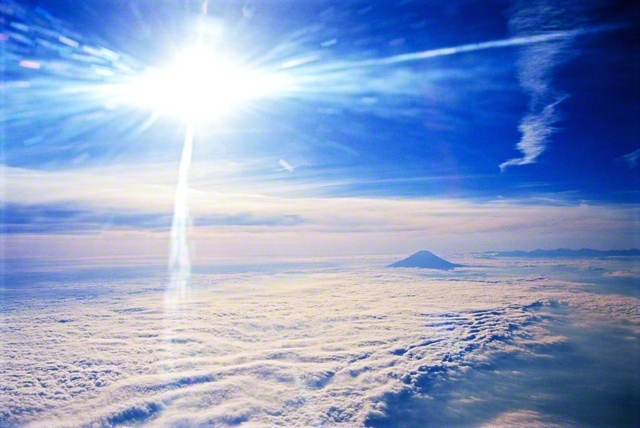 まばゆい陽光が雲海に降り注ぐ。かなたには富士山のシルエットが浮かぶ。太陽が地球をあまねく照らすように、今、仏法の英知は世界中に光を送る（2000年11月、池田先生撮影）