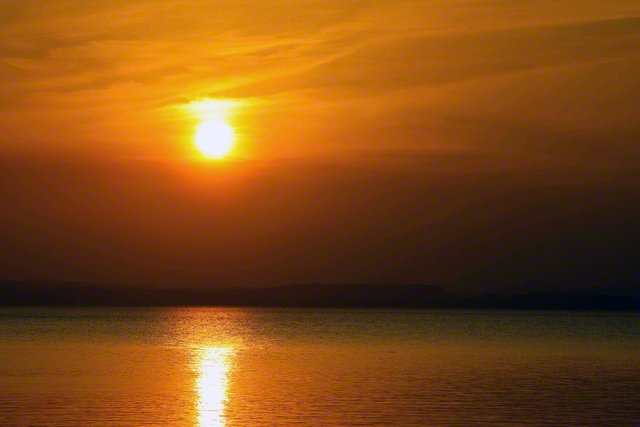 水俣の夕日が燃える。一幅の名画のよう。坂本さんの詩にある。＜愛おしさと懐かしさを呼ぶ海であった/母の慈しみが溶けた海であった＞