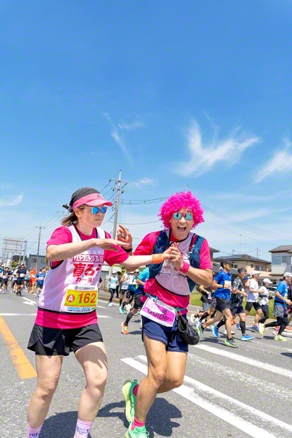 互いの歩幅を合わせて伴走する小野さん㊨。触手話で景色なども伝え、2人で楽しみながら（先月19日、かすみがうらマラソン兼国際ブラインドマラソン2026で）