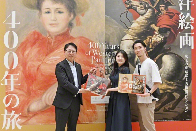 京都市京セラ美術館の小林中副館長㊧から森本さん夫妻に記念品が贈られた