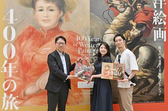 京都市京セラ美術館の小林中副館長㊧から森本さん夫妻に記念品が贈られた