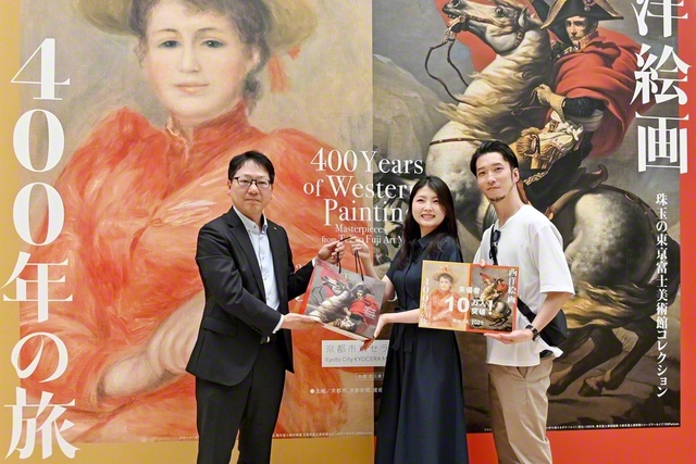 京都市京セラ美術館の小林中副館長㊧から森本さん夫妻に記念品が贈られた