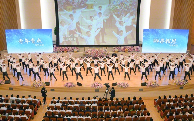 男子部の代表が学会歌「紅の歌」の指揮を力強く