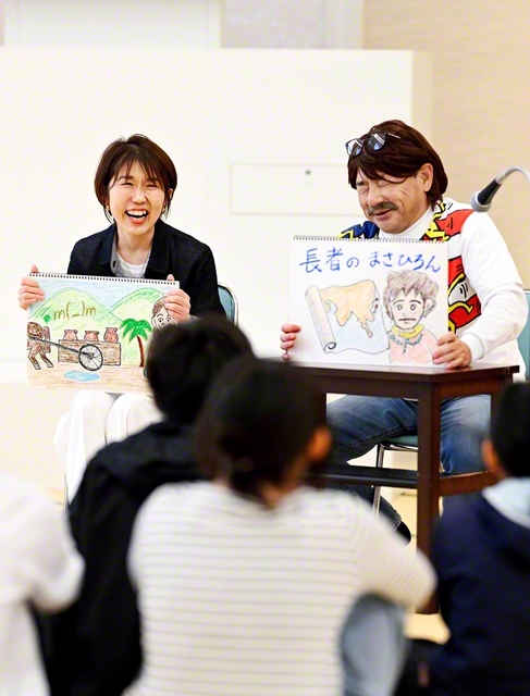 紙芝居を披露する“まさひろん”こと正広さん㊨。由美さんの飾らないリアクションがあってこそ笑いが成立する