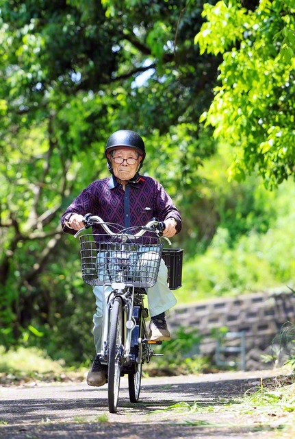 電動自転車をスイスイこぐ貞男さん。「お気を付けて」と言う間に、角を曲がっていた