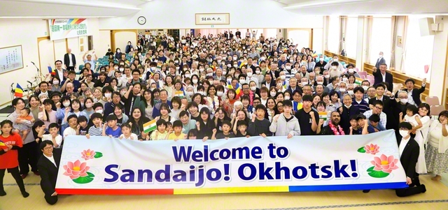 オホーツク県とインドの友が記念のカメラに。集いでは未来部の代表が英語であいさつし、「オホーツク未来の翼合唱団」が爽やかな歌声を披露した。有志のバンド演奏に続き、三谷弘教さんが8年前のインドSGIとの交流で受けた触発を胸に、社会で奮闘する模様を報告。インドのマーダビ・ボスレさんは数々の困難を乗り越え、人間革命を果たした歓喜を発表した
