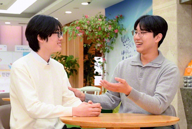 男子部メンバーと笑顔で語り合う金建佑さん㊨