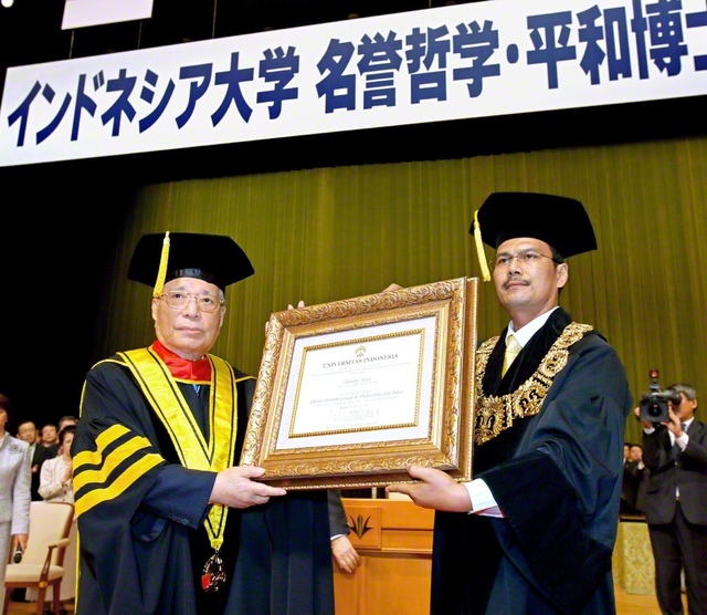 インドネシア大学の「名誉哲学・平和博士号」授与式。グミラル学長㊨（当時）から学位記が贈られた（2009年10月、東京・八王子市の創価大学で）