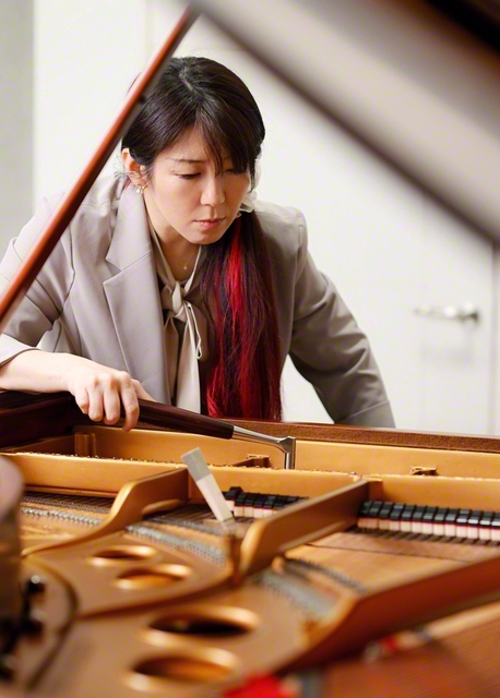 チューニングハンマーを手にピアノを調律する藤田さん。奏者に思いをはせながら、耳と指先の感覚を研ぎ澄ましている