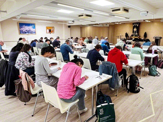 教学こそ人生を開く羅針盤！――忙しい合間を縫って人間主義の哲学を学んできた友が、真剣なまなざしで答案用紙に向かう（ベルギー文化会館で）