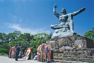 平和祈念像に祈りをささげる池田先生（1982年5月、長崎で）。天を指す右手は原爆を示し、水平に伸ばした左手は平和を表現。柔らかに閉じた目は原爆犠牲者への冥福を祈る