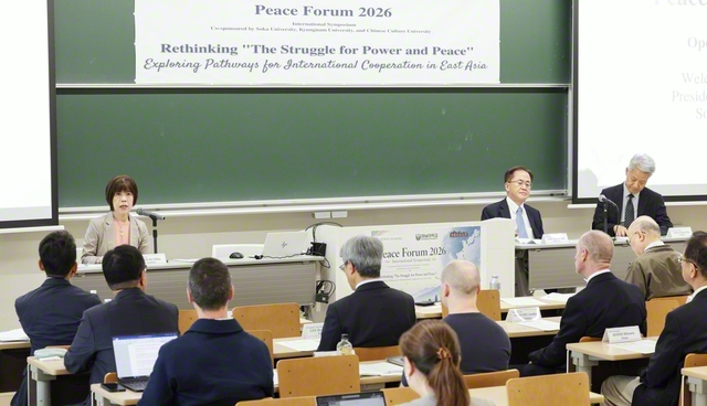 ピースフォーラムであいさつする創価大学の鈴木学長（左端）。フォーラムでは学生からも多くの質問が寄せられ、議論が交わされた（創大中央教育棟で）