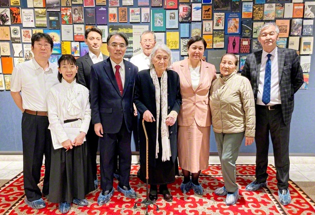 ビシュケク市のアイトマートフの家博物館で、アイトマートフ氏の妹であるローザさん（右から4人目）、キルギスのイサマートワ教育科学相（同3人目）らと学会の派遣団が記念のカメラに。博物館には世界中で出版された氏の著作が飾られている（5月18日）
