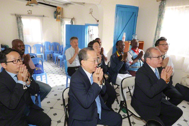 ナイロビ東支部の広布の会場を訪れた谷川SGI理事長。地元の壮年・男子部の友が歌を歌って大歓迎し、その後、ケニア広布を誓って唱題した（18日、ナイロビで）　