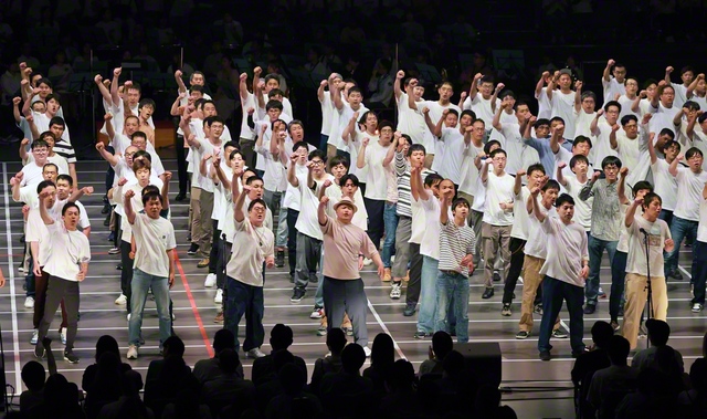 30代、40代の男性が力強く拳を突き上げ、励ましの歌声を轟かせた