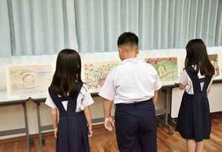 「沖縄戦の絵」を見学する児童ら。戦争の悲惨さと平和の尊さを胸に刻んだ（19日、宜野湾市内で）