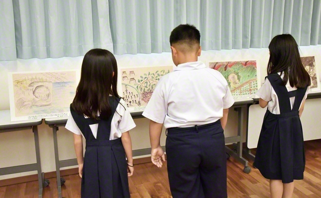 「沖縄戦の絵」を見学する児童ら。戦争の悲惨さと平和の尊さを胸に刻んだ（19日、宜野湾市内で）