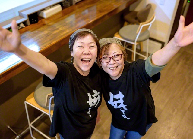 あつらえたばかりの「姉妹Tシャツ」を着る、姉の悦子さん㊧と妹の宏子さん。亡き両親から不屈の信心を受け継ぎ、「毎日が楽しくて仕方ない」