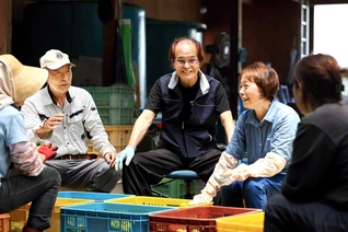 「雨風を耐え抜いて、きちっと実をならす。その生命力に負けんよう、私らも頑張りますよ」と竹田和久さん（右から3人目）と妻・圭子さん（同2人目）