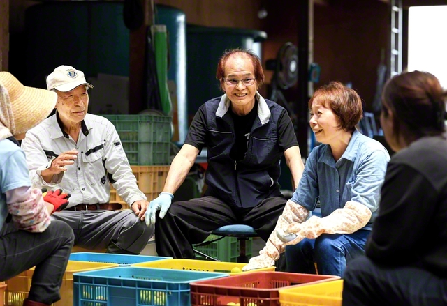 「雨風を耐え抜いて、きちっと実をならす。その生命力に負けんよう、私らも頑張りますよ」と竹田和久さん（右から3人目）と妻・圭子さん（同2人目）