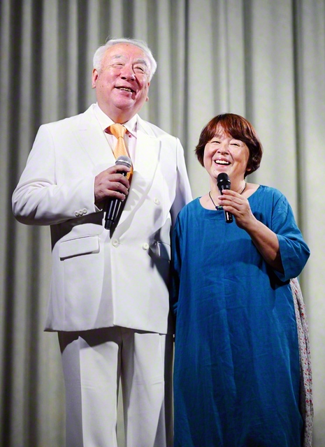 洋二さん㊧と優子さんが仲良くマイクを握る。夫婦の信心で「人生に行き詰まりはない」ことを証明してきた