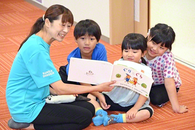 絵本の読み聞かせで、子どもたちをワクワクさせる新郷さん（左端）