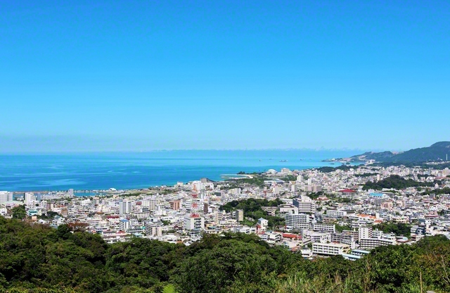 名護の市街地と名護湾。中央左に見える名護漁港の辺りは昔、浜辺だった。池田先生は1969年2月、そこで名護の友と出会いを結んだ