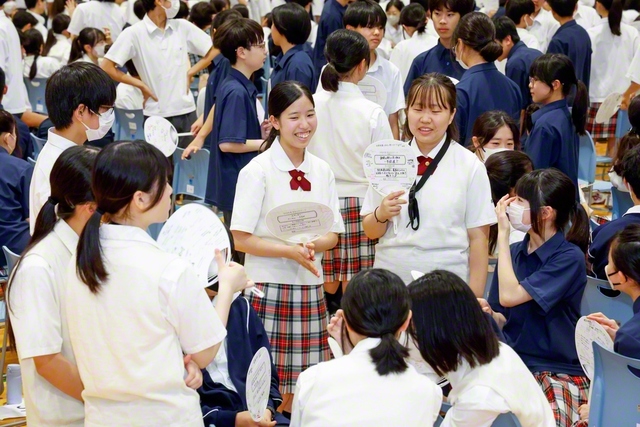 式典で、近くにいる人たちと互いの努力を語り合う東京中の生徒