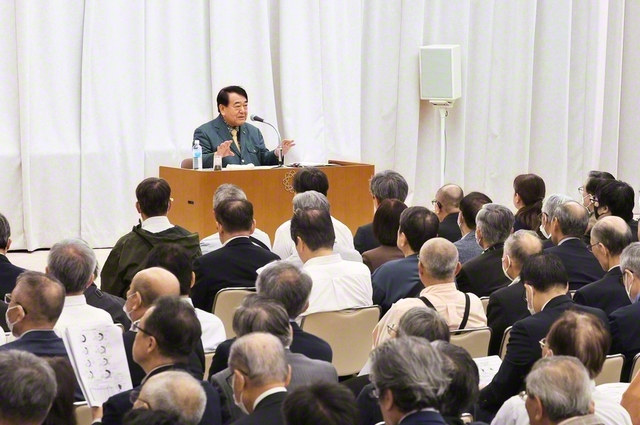 創価学会専門部主催の文化セミナーで講演する寺島会長。「アメリカファースト」「貯蓄から投資へ」といったキーワードやアメリカによる関税引き上げなどの100年を超えた共通性に触れつつ、その後の株価の大暴落と国家同士の経済的な対立が第2次世界大戦の遠因になったと指摘した（2025年10月、東京都内で）