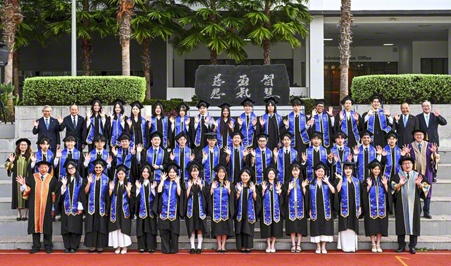 5カ国から集い合った卒業生が記念のカメラに。創立者・池田先生の筆による「智慧」「勇気」「慈悲」の文字が刻まれた「建学の精神」の碑の前で