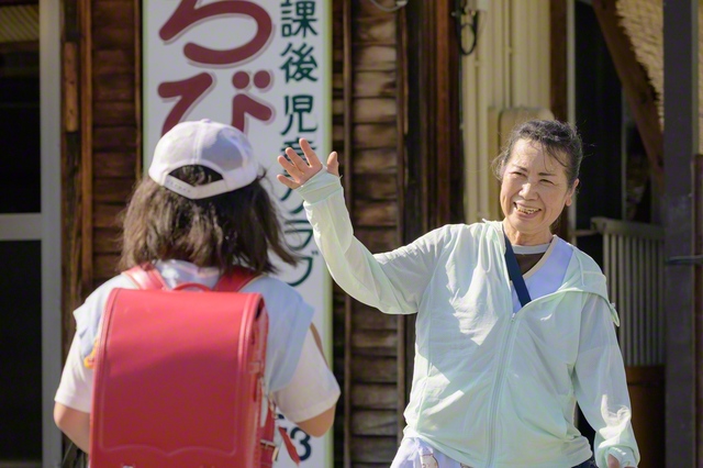 子どもたちを笑顔で迎える太田さん㊨