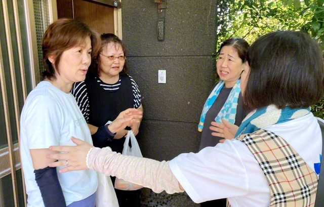 志賀県女性部長（右から2人目）らが増住さん（同3人目）と、近くに住む地区副女性部長の宮本洋子さん（左端）を励ます