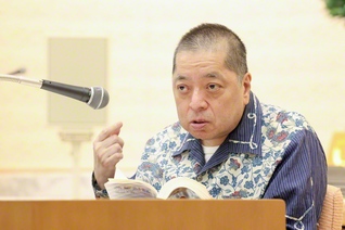 池田先生の著書『希望対話』を手に講演する佐藤さん（先月18日、東京・新宿区で）