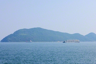高松港から望む女木島。瀬戸内海に、旅客船「ガンツウ」が浮かぶ