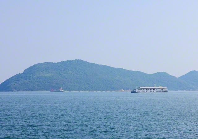 高松港から望む女木島。瀬戸内海に、旅客船「ガンツウ」が浮かぶ