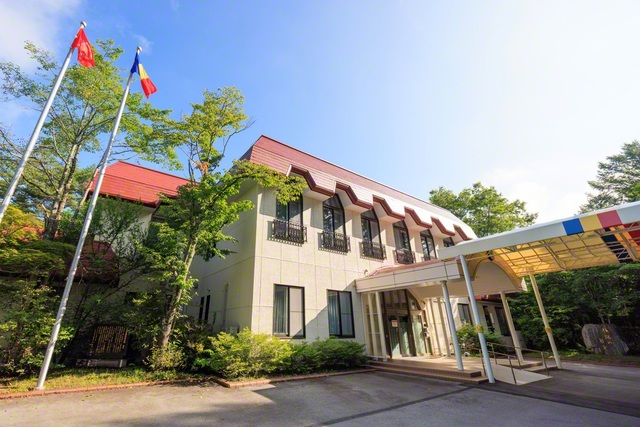 赤い屋根が映える本館の横には、三色旗と長野創価学会の旗が掲揚されている
