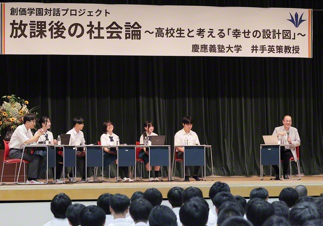 壇上や場内の生徒から寄せられた質問に対して、慶應義塾大学の井手英策教授が笑顔で答えた（関西創価学園・池田講堂で）