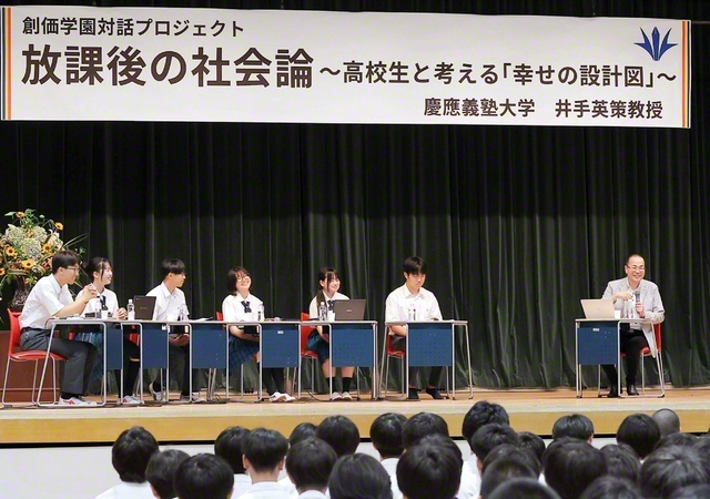 壇上や場内の生徒から寄せられた質問に対して、慶應義塾大学の井手英策教授が笑顔で答えた（関西創価学園・池田講堂で）