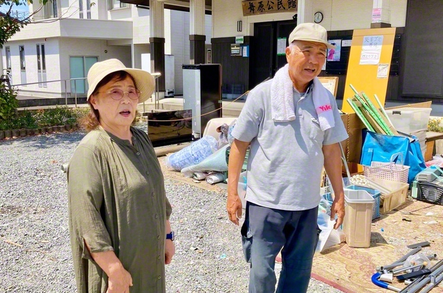 災害ごみ置き場に立つ村田さん㊨は「なーん、私なんかすごくなかですよ。当たり前のことばしよっとだけん」。情熱の“肥後もっこす”に妻・千穂子さんは明るく伴走する